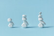 © Yaroslav Danylchenko/Stocksy - Three stacks of balancing white pebble stones.