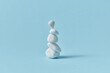© Yaroslav Danylchenko/Stocksy - White sea pebble stone stack on light blue background.