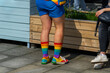 © Dima Sikorski/Stocksy - A person with shocking rainbow clothes and bright socks