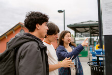 Teens Checking Routes At Train Stop