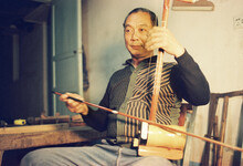 The Man Is Playing The Erhu

