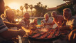 A group of energetic senior men laugh around a barbeque, cooking a meal at sunrise or sunset by the pool.