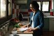 © Lightsy/Stocksy - Woman with recipe notes in the kitchen
