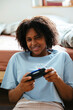 © BONNINSTUDIO/Stocksy - Woman playing video game on bedroom