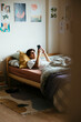 © BONNINSTUDIO/Stocksy - Teen boy using phone in bed