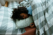© BONNINSTUDIO/Stocksy - Female teen sleeping on bed