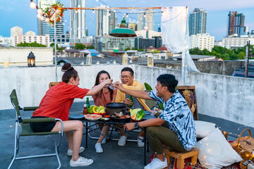 Wall Mural - Group of Diversity Asian people friends enjoy and fun celebration meeting dinner party eating barbecue grill and drinking Korean vodka together at outdoor rooftop on summer holiday vacation at night.