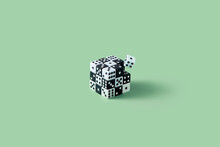Cube Made Of Black And White Dice Against Green Background.