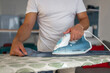 © Lupe Rodríguez/Stocksy - young man ironing clothes at home