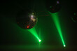 © Luciano Spinelli/Stocksy - Backlit disco ball against green light at party with copy space