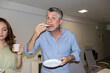 © Pedro Merino/Stocksy - Lo-Fi direct flash photo of a mature man eating pizza in the office
