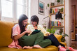 © Ibai Acevedo/Stocksy - Mother and daughter enjoying online shopping on the sofa