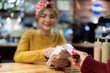 © Alvaro Lavin/Stocksy - Customer making contactless payment.