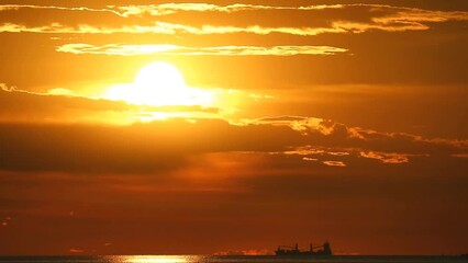 Wall Mural - sunset back on the dark cloud on the ocean and silhouette cargo ship on the horizon