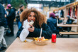 © Daniel Gonzalez/Stocksy - Female enjoying fast food in street cafeteria