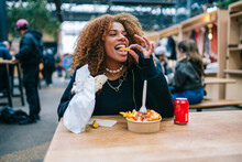Happy Black Lady Biting Fast Food In Street Cafe