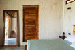 © Shava Cueva/Stocksy - The interior of a room in a beach house with an empty bed