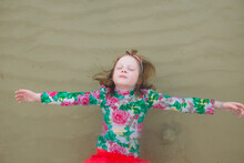 Little Girl Floats In Shallow Sea Water