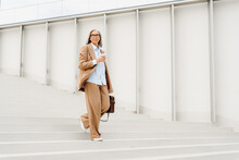 An Businesswoman Walks Down The Stairs Outdoors