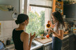 © Léa Jones/Stocksy - two young women drinking tea/water in kitchen