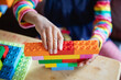 © Anya Brewley Schultheiss/Stocksy - Closeup of a child's hands as she plays with blocks