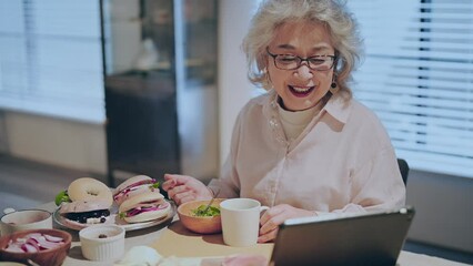 Wall Mural - テレビ電話で遠方に住む家族とのコミュニケーションを楽しむシニア女性