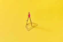 Pink Compass And Protractor On Bright Yellow Background.