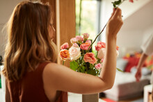 Woman Puts A Rose In A Vase