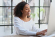 © Katsiaryna - Happy african american woman using laptop work study in office
