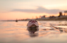 Woman Face Floating In Sea Shore