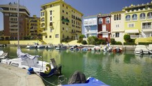 Walk Through The Streets And Canals Of The Port Of Saplaya On A Sunny Day. Moored Yachts And Boats At The Bright Facades Of Houses. Spain