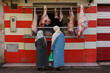© BTWImages - Morocco. Taroudant. Two women in traditional dress in front of a storefront of a butcher's shop