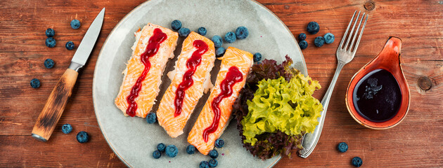 Wall Mural - Fried salmon fillet on a wooden table.