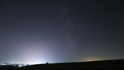Poster - spectacular timelapse of the milky way next to a city at night. romania in a clear summer night