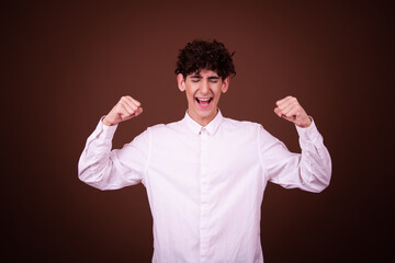 Sticker - Funny young guy posing in the studio on a brown background.