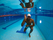 Professional Swimmer Approving His Underwater Swimming Workout In Pool