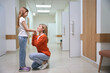 © Viacheslav Yakobchuk - Female in an orange sweater holds the girls hand in the clinic