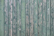 Weathered green painted wooden laths on a house.