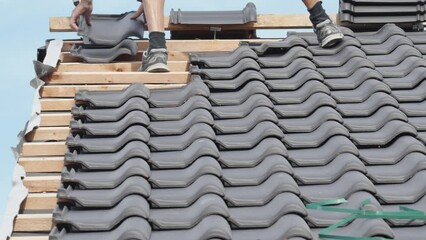 Wall Mural - tiler laying ceramic tiles on the roof of the house