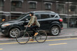 © Oleksandr Kozak - Woman rides bicycle fast in the street with blurred in motion background