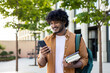 © Tetiana - Young smiling Indian male student came to study, standing outside campus, university and using phone. He was holding books and a backpack