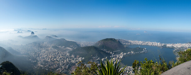 Wall Mural - Rio de Janeiro, Brazil: skyline with stunning view of the city in the morning mist seen from the Christ the Redeemer on Mount Corcovado with Sugarloaf Mountain, Copacabana beach and lagoon