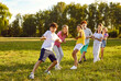 © Studio Romantic - Happy kids playing games and having fun in summer camp on vacation. Team of children playing tug of war, standing on green field and pulling rope all together. Summer, fun, activity, teamwork concept