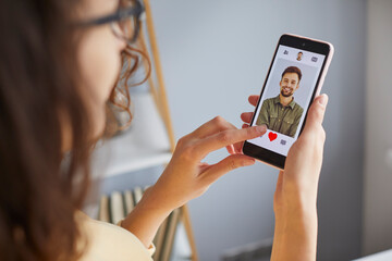 young woman using dating app on mobile phone. close up shot of attractive woman swiping and liking u