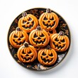 Leinwandbild Motiv Plate of Halloween Jack o'Lantern Cookies Isolated on a White Background