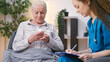 General practitioner prescribing pills to senior woman, personal home care