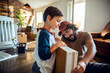 © Marko Geber - Young caucasian boy helping his father assemble the new furniture after moving in into their new home apartment