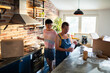 © Marko Geber - Young female lesbian couple decorating and moving in their new home apartment