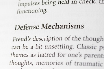 Close-up of the psychological term Defense Mechanisms on paper background