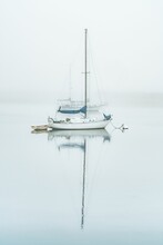 Sailboat Moored In The Misty Morro Bay On A Peaceful Morning.